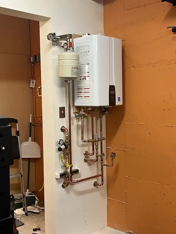 Plumbing technician inspecting water heater connections in Kalama
